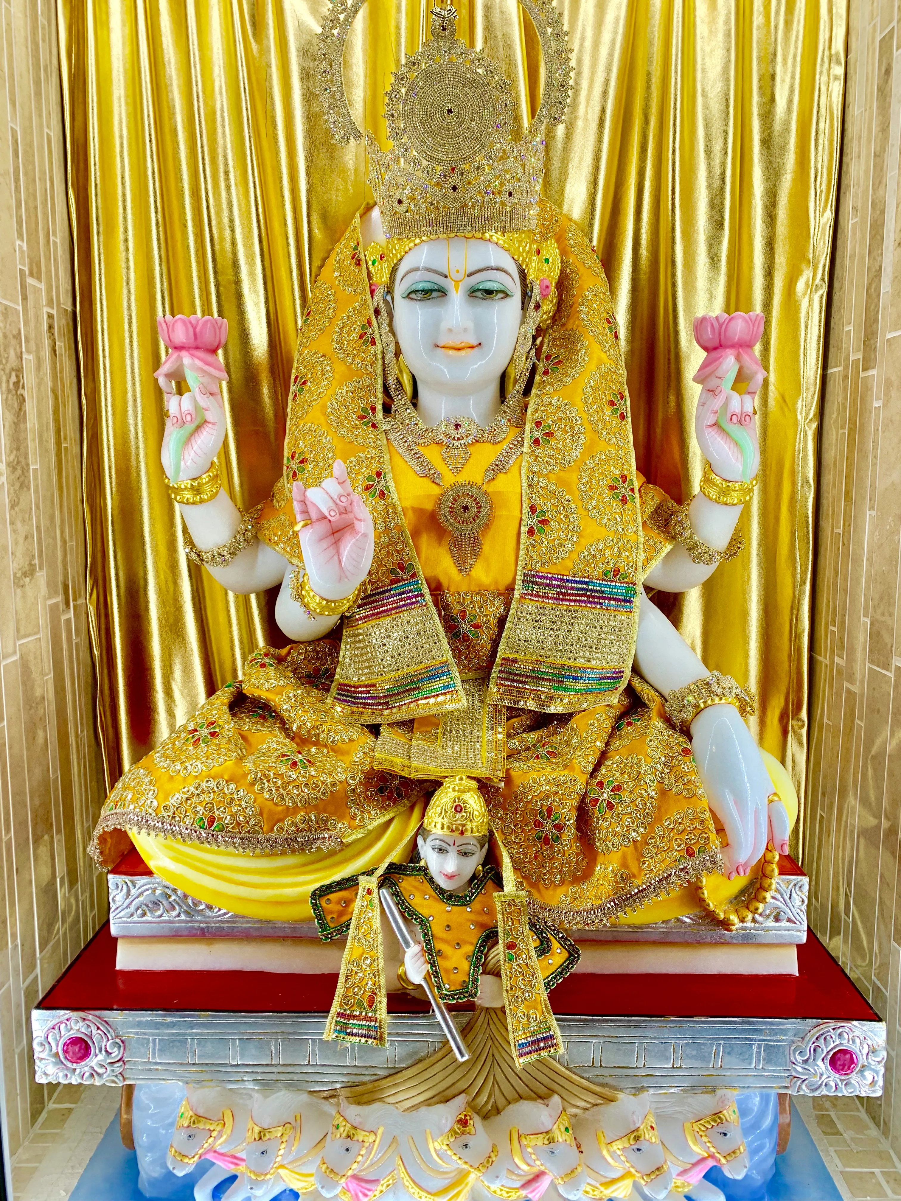 The murti of Surya Dev, the Sun God — seated in gold, holding lotuses, with a radiant sun disc behind him and his charioteer below